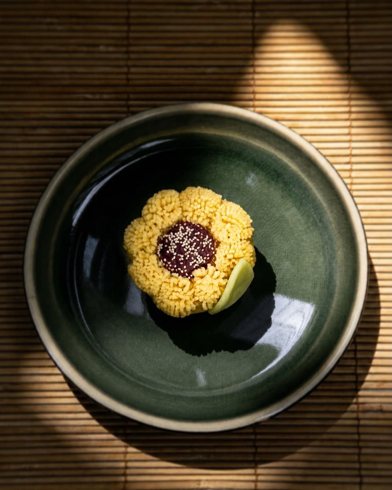 Yellow sunflower-shaped nerikiri with a red bean centre